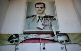 Une affiche déchirée montrant le défunt président syrien Hafez Assad et son fils le dictateur syrien déchu Bashar el-Assad, qui ont été placés à l'entrée du célèbre centre de détention de sécurité appelé Palestine Branch, à Damas, en Syrie, le 14 décembre 2024. (Crédit : Hussein Malla/AP)