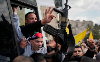 Des prisonniers palestiniens accueillis à la sortie d'un bus de la Croix-Rouge après avoir été libérés d'une prison israélienne dans le cadre d'un accord de libération d'otages et de cessez-le-feu entre Israël et le Hamas, à Ramallah, en Cisjordanie, le 1er février 2025. (Crédit : Nasser Nasser/AP)