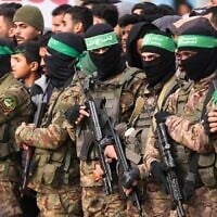 Des terroristes armés du Hamas se tenant en formation avant une libération d'otages, à Deir al-Balah, au centre de la bande de Gaza, le 8 février 2025. (Crédit : Abdel Kareem Hana/AP)