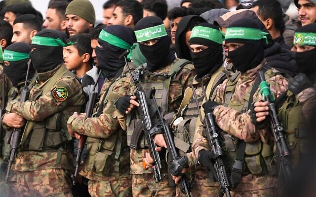 Des terroristes armés du Hamas se tenant en formation avant une libération d'otages, à Deir al-Balah, au centre de la bande de Gaza, le 8 février 2025. (Crédit : Abdel Kareem Hana/AP) Des terroristes armés du Hamas se tenant en formation avant une libération d'otages, à Deir al-Balah, au centre de la bande de Gaza, le 8 février 2025. (Crédit : Abdel Kareem Hana/AP)