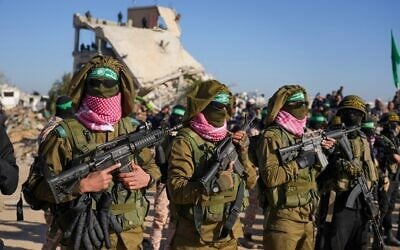 Des terroristes armés du Hamas, portant des uniformes volés à l'armée israélienne avant la remise de trois otages israéliens, à Khan Younès, dans la bande de Gaza, le 15 février 2025. (Crédit : Abdel Kareem Hana/AP) Des terroristes armés du Hamas, portant des uniformes volés à l'armée israélienne avant la remise de trois otages israéliens, à Khan Younès, dans la bande de Gaza, le 15 février 2025. (Crédit : Abdel Kareem Hana/AP)