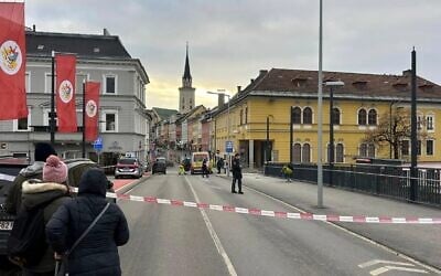 Des personnes regardent la zone bouclée où un homme a poignardé plusieurs personnes dans la ville de Villach, dans le sud de l'Autriche, le 15 février 2025. (Crédit : Wiesflecker/Kleine Zeitung via AP)