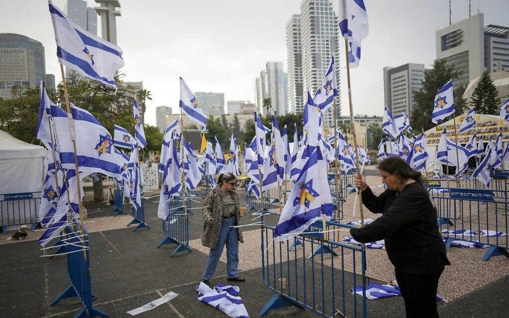 Des drapeaux israéliens sont déployés avant la restitution par le Hamas des corps de quatre otages israéliens, dont Shiri Bibas et ses deux enfants, sur la Place des Otages, à Tel Aviv, en Israël, le 20 février 2025. (Crédit : Oded Balilty/AP)