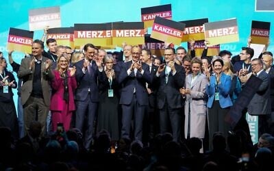 Friedrich Merz, le candidat principal de la CDU à la chancellerie, et les membres du comité directeur du parti applaudissent sur la scène lors de la principale campagne électorale de l'Union chrétienne-démocrate, le 21 février 2025, à Oberhausen, en Allemagne, avant les élections fédérales allemandes de dimanche au Bundestag. (Crédit : AP/Martin Meissner)