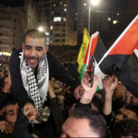 Zakaria Zubeidi, 49 ans, prisonnier palestinien et ancien haut commandant des Brigades des martyrs d'Al-Aqsa, libéré par Israël, agite un drapeau palestinien sous les acclamations de la foule après son arrivée à Ramallah, le 30 janvier 2025. (Crédit : AHMAD GHARABLI / AFP)