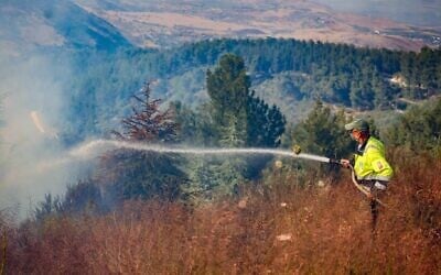 Des pompiers israéliens tentent d'éteindre un incendie allumé par le fragment d'un missile d'interception dans la forêt de Biriya, dans le nord d'Israël, le 4 juin 2024. (Crédit : David Cohen/Flash90)