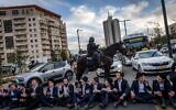 Des extrémistes ultra-orthodoxes opposés à la circonscription s'opposent à la police devant les lieux d'une conférence concernant les soldats haredi, à Jérusalem, le 28 janvier 2025. (Chaim Goldberg/Flash90)