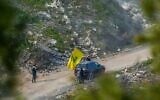 Des Libanais agitent le drapeau du Hezbollah dans le Sud-Liban et sont visibles depuis la frontière israélienne, le 18 février 2025. (Ayal Margolin/Flash90)