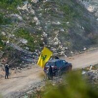 Des Libanais agitent le drapeau du Hezbollah dans le Sud-Liban et sont visibles depuis la frontière israélienne, le 18 février 2025. (Ayal Margolin/Flash90)