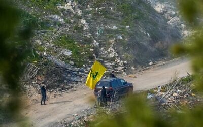 Des Libanais agitent le drapeau du Hezbollah dans le Sud-Liban et sont visibles depuis la frontière israélienne, le 18 février 2025. (Ayal Margolin/Flash90)