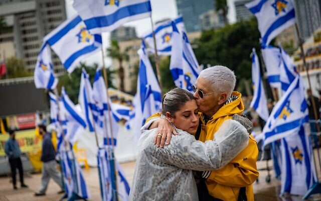 Des personnes s'embrassant sur la Place des Otages à Tel Aviv après que le Hamas a remis les corps de quatre otages tués pour qu'ils soient rendus à Israël, le 20 février 2025. (Crédit : Chaïm Goldberg/Flash90)
