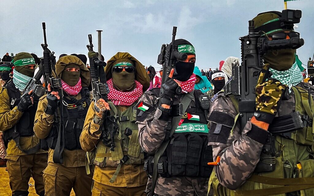 Des terroristes armés du Hamas sur le lieu prévu pour la remise des corps de quatre otages, incluant Shiri Bibas et ses deux jeunes enfants, à Khan Younès, dans le sud de Gaza, le 20 février 2025. (Crédit : Saeed Mohammed/Flash90)