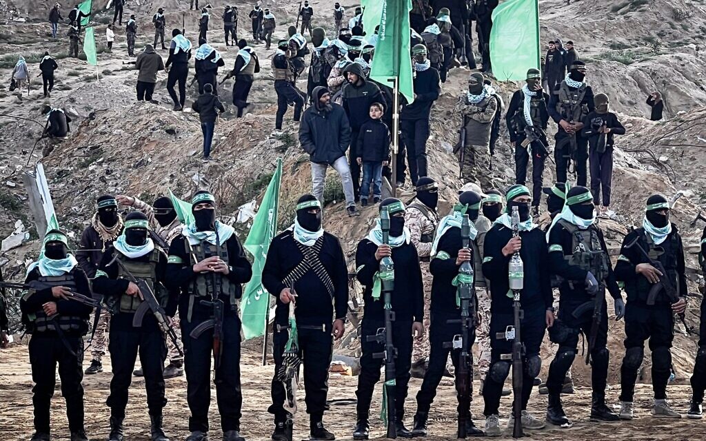 Des terroristes armés du Hamas sur le lieu prévu pour la remise des corps de quatre otages, incluant Shiri Bibas et ses deux jeunes enfants, à Khan Younès, dans le sud de Gaza, le 20 février 2025. (Crédit : Saeed Mohammed/Flash90)