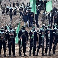 Des terroristes armés du Hamas sur le lieu prévu pour la remise des corps de quatre otages, incluant Shiri Bibas et ses deux jeunes enfants, à Khan Younès, dans le sud de Gaza, le 20 février 2025. (Crédit : Saeed Mohammed/Flash90)