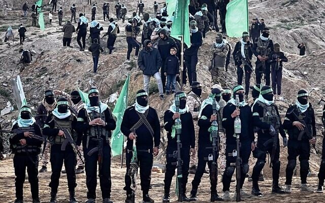 Des terroristes armés du Hamas sur le lieu prévu pour la remise des corps de quatre otages, incluant Shiri Bibas et ses deux jeunes enfants, à Khan Younès, dans le sud de Gaza, le 20 février 2025. (Crédit : Saeed Mohammed/Flash90)