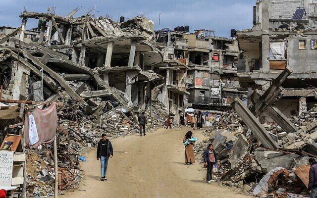 Des Palestiniens errent parmi les décombres de leurs maisons, détruites durant la guerre entre Israël et le Hamas, dans la ville de Khan Younès, dans le sud de la bande de Gaza, le 23 février 2025. (Crédit : Abed Rahim Khatib/Flash90)