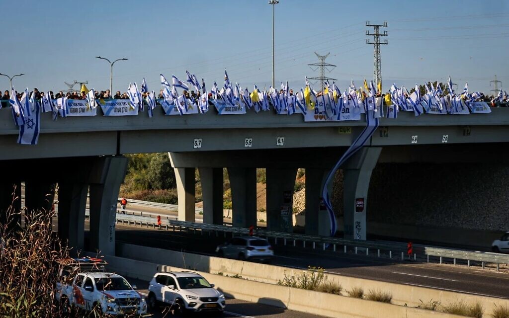 Des foules se rassemblent pour rendre hommage aux membres de la famille Bibas assassinés alors que leur cortège funèbre passe à l'intersection de Gan Yavne, le 26 février 2025 (Crédit : Yossi Aloni/Flash90)