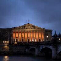 La colonnade du Palais-Bourbon de l'Assemblée nationale française, éclairée en orange en hommage aux otages assassinés Shiri, Ariel et Kfir Bibas, à Paris, le 26 février 2025. (Crédit : X / @AssembleeNat / utilisée conformément à l'article 27a de la loi sur le droit d'auteur)