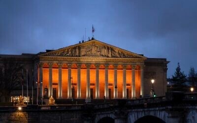 La colonnade du Palais-Bourbon de l'Assemblée nationale française, éclairée en orange en hommage aux otages assassinés Shiri, Ariel et Kfir Bibas, à Paris, le 26 février 2025. (Crédit : X / @AssembleeNat / utilisée conformément à l'article 27a de la loi sur le droit d'auteur)