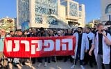 Des manifestants tiennent une banderole qui dit « Nous avons été abandonnés », lors d'une marche pour protester contre les violences à l'encontre du personnel, le 4 février 2025. (Diana Bletter/Times of Israel)