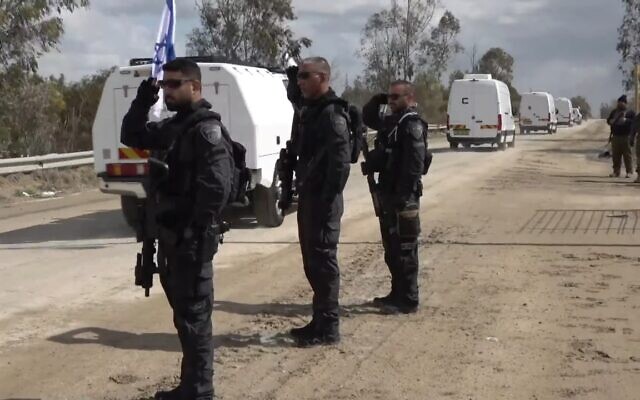 Des officiers saluant un convoi de véhicules de l'armée israélienne, escortés par la police israélienne, transportant des cercueils contenant vraisemblablement les dépouilles de quatre otages à l'institut médico-légal d'Abu Kabir, dans le centre d'Israël, le 20 février 2025. (Crédit : Capture d'écran/Police israélienne)