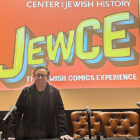 Kaplan pose sous le logo JewCE à JewCE : The Jewish Comics Experience au Center for Jewish History à Manhattan, le 10 novembre 2024. (Crédit : Jay Deitcher)