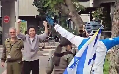 L'otage libéré Ofer Calderon levant les deux mains et embrassant ses amis devant le centre hospitalier de Sheba lors de son retour en Israël, le 1er février 2025. (Crédit : Capture d'écran X ; utilisée conformément à la clause 27a de la loi sur les droits d'auteur)