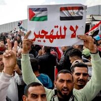 Illustration : Un homme brandissant une pancarte « Non au déplacement » lors d'une manifestation contre le plan du président américain Donald Trump de prendre le contrôle de Gaza, du côté égyptien du poste-frontière de Rafah, le 31 janvier 2025. (Crédit : Kerolos Salah/AFP)