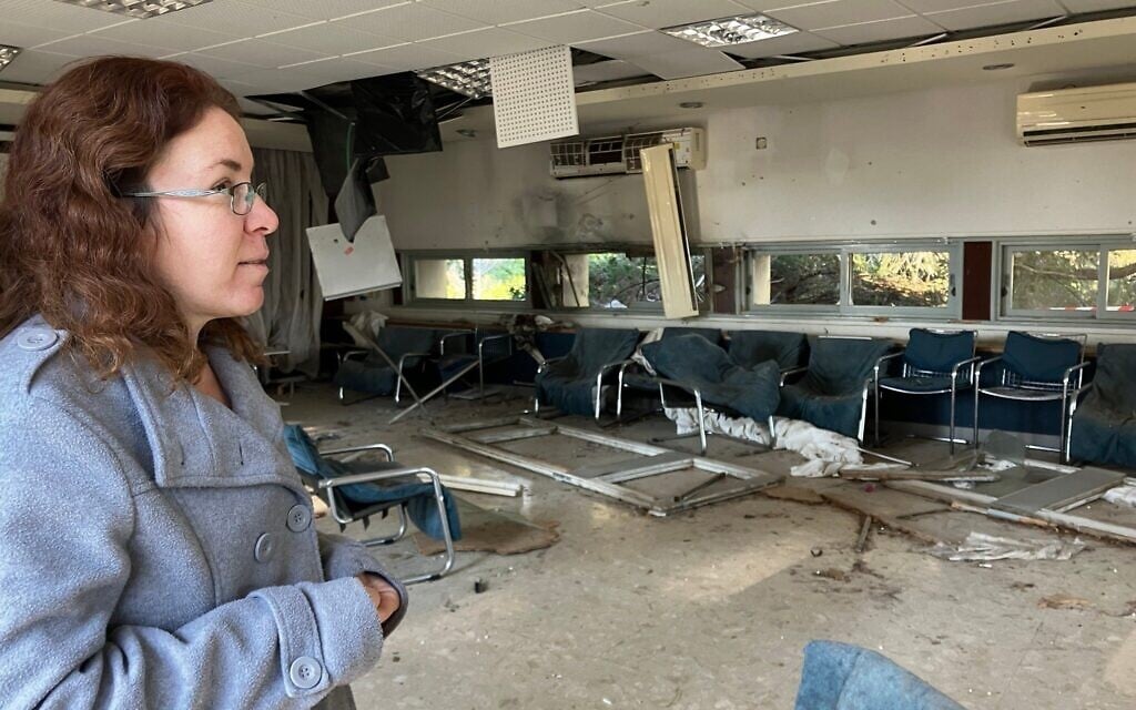 Efrat Amir, une résidente du kibboutz Adamit, examine les dégâts causés par les roquettes du Hezbollah sur le centre communautaire du kibboutz, le 2 mars 2025. (Crédit : Diana Bletter/Times of Israel)