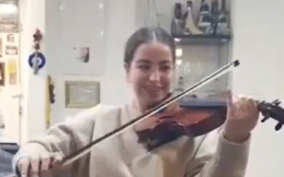 L'otage libérée Agam Berger joue un violon ayant appartenu à un musicien juif assassiné pendant la Shoah, le 8 mars 2025. (Crédit : Capture d'écran/Ynet ; utilisé conformément à l'article 27a de la loi sur le droit d'auteur)