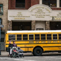 Des femmes avec des poussettes devant l'école juive religieuse, Kehilath Yakov, dans le quartier de South Williamsburg, le 9 avril 2019 dans l'arrondissement de Brooklyn à New York. (Crédit : Drew Angerer / Getty Images North America / Getty Images via AFP)