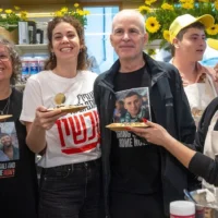 (De gauche à droite) : L'ex-otage Aviva Siegel, sa fille Shir et son mari, l'otage récemment libéré Keith, célèbrent l'ouverture de la maison de crêpes Keit Siegel au marché Sarona à Tel Aviv, le 26 mars 2025. (Crédit : Miriam Alster/Flash90)