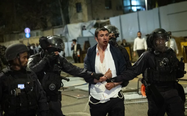 Un jeune ultra-orthodoxe arrêté par la police lors d'émeutes à un rassemblement contre la conscription des haredim dans Tsahal, à Jérusalem, le 27 mars 2025. (Crédit : Chaim Goldberg/Flash90)