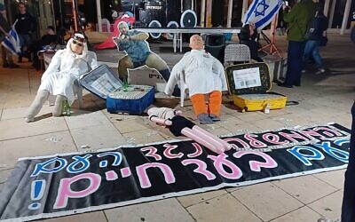 Une installation dénonçant les liens présumés entre le Qatar et les principaux collaborateurs du Premier ministre Benjamin Netanyahu, lors d'une manifestation anti-gouvernement, sur la Place Habima, à Tel Aviv le 8 mars 2025. (Crédit : Noam Lehmann/The Times of Israel)