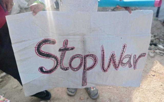 Un manifestant anti-guerre palestinien tient une pancarte à Beit Lahiya, dans le nord de la bande de Gaza, le 25 mars 2025. (utilisé conformément à l'article 27a de la loi sur le droit d'auteur)