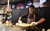 Raif Rashed, Druze israélien propriétaire de Taboonia, dépose du labneh sur une pita à New York, en mars 2025. (Crédit : Jackie Hajdenberg/ JTA)