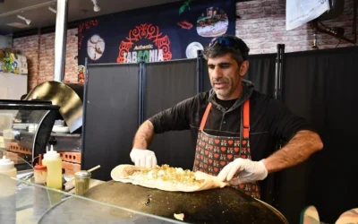 Raif Rashed, Druze israélien propriétaire de Taboonia, dépose du labneh sur une pita à New York, en mars 2025. (Crédit : Jackie Hajdenberg/ JTA)