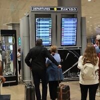 Des passagers consultent le panneau des vols à l'aéroport Ben Gurion, alors que les vols sont annulés et retardés en raison de l'assaut du Hamas, le 7 octobre 2023. (Crédit : Gil Cohen-Magen/AFP)
