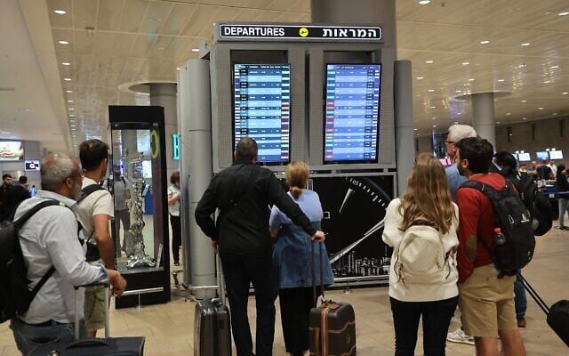 Des passagers consultent le panneau des vols à l'aéroport Ben Gurion, alors que les vols sont annulés et retardés en raison de l'assaut du Hamas, le 7 octobre 2023. (Crédit : Gil Cohen-Magen/AFP) Des passagers consultent le panneau des vols à l'aéroport Ben Gurion, alors que les vols sont annulés et retardés en raison de l'assaut du Hamas, le 7 octobre 2023. (Crédit : Gil Cohen-Magen/AFP)