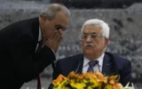 Le directeur des renseignements généraux palestiniens en Cisjordanie, Majid Faraj (à gauche), chuchote au président de l'Autorité palestinienne Mahmoud Abbas lors d'une réunion où il a demandé à rejoindre 15 agences des Nations unies, renonçant ainsi à ses promesses de s'abstenir de le faire pendant neuf mois de négociations qui devaient se terminer le 29 avril, à son siège dans la ville de Ramallah en Cisjordanie, le 1er avril 2014. (Crédit : ABBAS MOMANI / AFP)