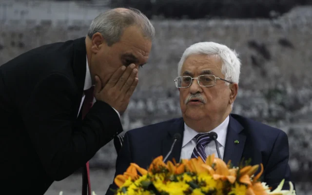 Le directeur des renseignements généraux palestiniens en Cisjordanie, Majid Faraj (à gauche), chuchote au président de l'Autorité palestinienne Mahmoud Abbas lors d'une réunion où il a demandé à rejoindre 15 agences des Nations unies, renonçant ainsi à ses promesses de s'abstenir de le faire pendant neuf mois de négociations qui devaient se terminer le 29 avril, à son siège dans la ville de Ramallah en Cisjordanie, le 1er avril 2014. (Crédit : ABBAS MOMANI / AFP) Le directeur des renseignements généraux palestiniens en Cisjordanie, Majid Faraj (à gauche), chuchote au président de l'Autorité palestinienne Mahmoud Abbas lors d'une réunion où il a demandé à rejoindre 15 agences des Nations unies, renonçant ainsi à ses promesses de s'abstenir de le faire pendant neuf mois de négociations qui devaient se terminer le 29 avril, à son siège dans la ville de Ramallah en Cisjordanie, le 1er avril 2014. (Crédit : ABBAS MOMANI / AFP)