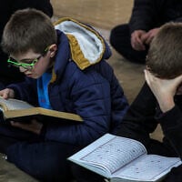 De jeunes fidèles musulmans lisent le Coran, le livre sacré de l'islam, à la mosquée Rahman le premier jour du mois sacré musulman du ramadan dans la ville d'Alep, au nord de la Syrie, le 1er mars 2025. (Photo par OMAR HAJ KADOUR / AFP)