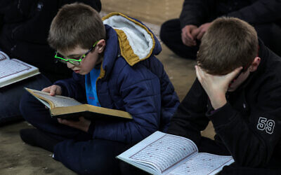 De jeunes fidèles musulmans lisent le Coran, le livre sacré de l'islam, à la mosquée Rahman le premier jour du mois sacré musulman du ramadan dans la ville d'Alep, au nord de la Syrie, le 1er mars 2025. (Photo par OMAR HAJ KADOUR / AFP)