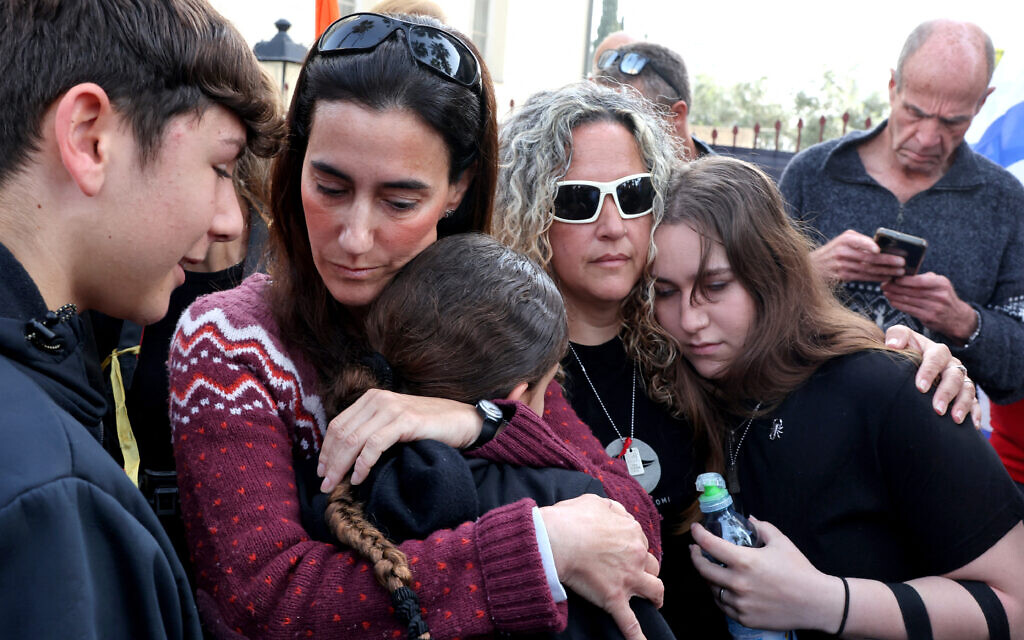 Batsheva Yahalomi (au centre à gauche), l'épouse du Franco-Israélien Ohad Yahalomi, l'un des otages israéliens capturés par des terrorsites palestiniens dans la bande de Gaza lors des attentats du 7 octobre 2003, pleure avec sa sœur Effie (au centre à droite) devant la morgue où son corps a été conservé avant ses funérailles, à Rishon LeZion, dans le centre d'Israël, le 5 mars 2005. (Crédit : Jack Guez/AFP)