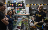 Yonatan Baleli, vendeur dans un stand de sandwichs, prépare une commande pour des clients dans la ville de Shlomi, au nord d'Israël, près de la frontière avec le Liban, le 3 mars 2025, après qu'Israël a demandé aux habitants des régions du nord de commencer à retourner dans leurs villes après un accord de cessez-le-feu du 27 novembre avec le Liban. (Crédit : KAHANA / AFP)