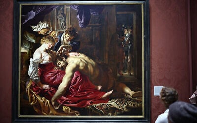 Des membres du public étudient « Samson et Dalila », une huile sur toile de 1610 attribuée au peintre flamand Peter Paul Rubens à la National Gallery de Londres, le 3 mars 2025. (Crédit : HENRY NICHOLLS / AFP)