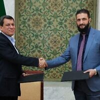 Le président par intérim syrien Ahmed al-Sharaa (à droite) serrant la main du commandant en chef des Forces démocratiques syriennes (FDS) Mazloum Abdi après la signature d'un accord visant à intégrer les institutions de l'administration kurde semi-autonome du nord-est dans le gouvernement national, dans la capitale syrienne Damas, le 10 mars 2025. (Crédit : SANA / AFP)