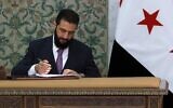 Le président syrien par intérim, Ahmad al-Sharaa, signant la déclaration constitutionnelle du pays, qui devrait s'appliquer pour une période transitoire de cinq ans, au palais présidentiel de Damas, le 13 mars 2025. (Crédit : Bakr Alkasem/AFP)