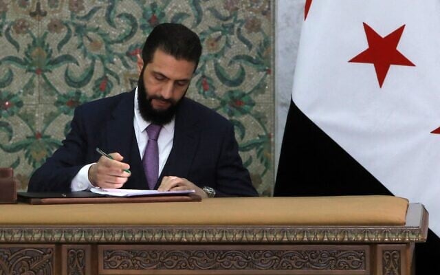 Le président syrien par intérim, Ahmad al-Sharaa, signant la déclaration constitutionnelle du pays, qui devrait s'appliquer pour une période transitoire de cinq ans, au palais présidentiel de Damas, le 13 mars 2025. (Crédit : Bakr Alkasem/AFP)