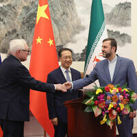 De gauche à droite; le vice-ministre russe des affaires étrangères, Sergei Ryabkov, le vice-ministre chinois des affaires étrangères, Ma Zhaoxu, et le vice-ministre iranien des affaires étrangères, Kazem Gharibabadi, tiennent une conférence de presse à l'issue de leur réunion à la maison d'hôtes d'État Diaoyutai, à Pékin, le 14 mars 2025. (Crédit : Lintao Zhang / POOL / AFP)